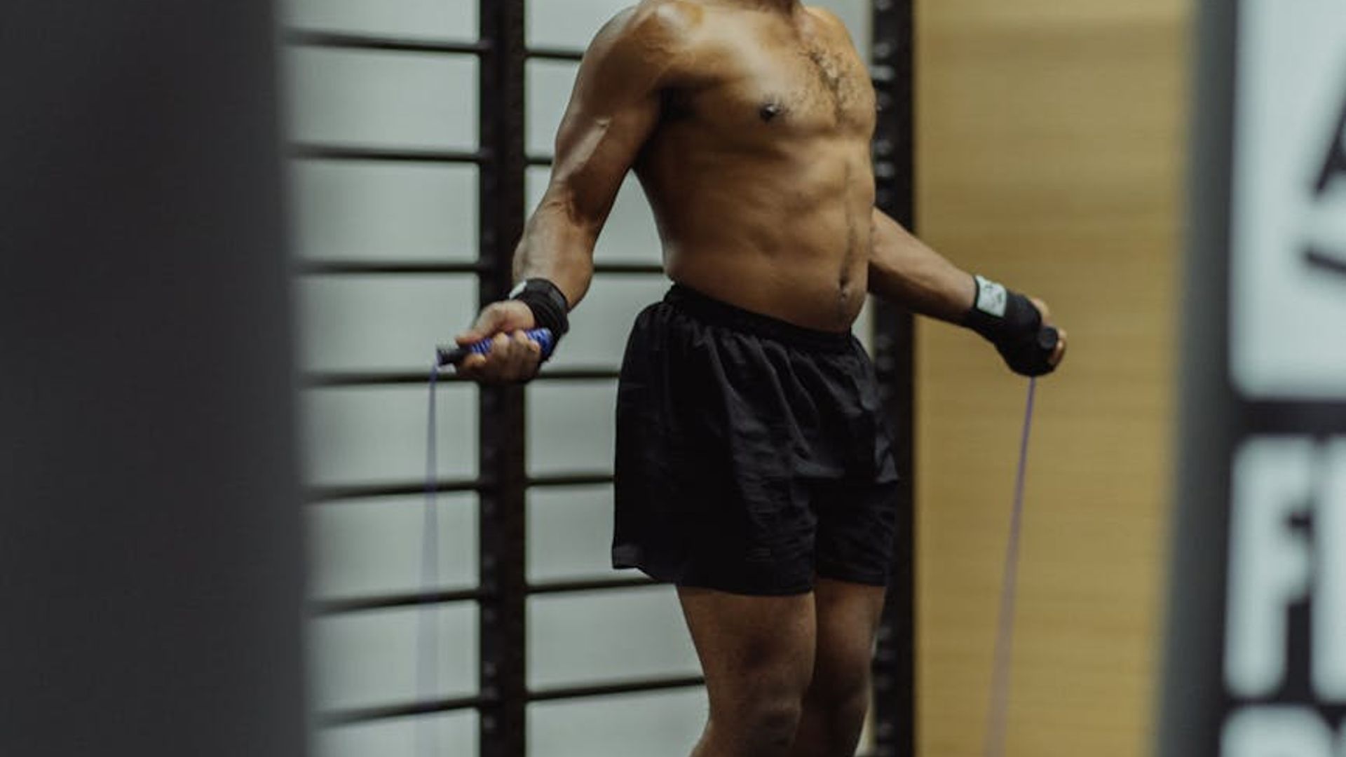 Athletic man focused on precise strength movement in gym.