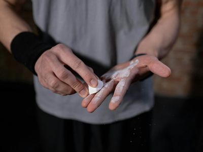 Close-up of hands gripping a bar with chalk.