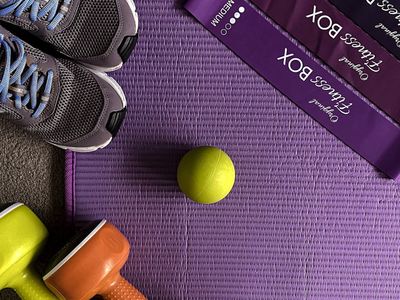 Dumbbells and resistance bands on a clean floor.
